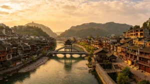 Fenghuang Ancient Town and Tuojiang River at sunset, with traditional riverside wooden houses and bridges